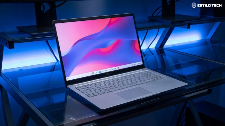 Um notebook aberto exibindo uma tela colorida de alta resolução em uma mesa de trabalho de vidro fumê com iluminação LED azulada ao fundo